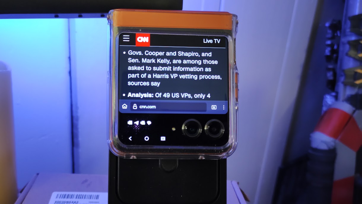 A Moto Razr 2024 sitting on a MagSafe dock, displaying a web page while folded.